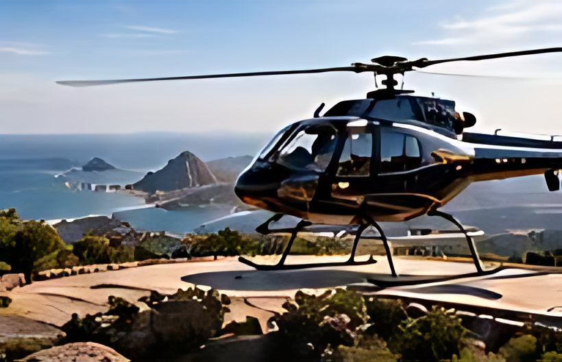 A helicopter waiting on a cliff-top pad above the coast