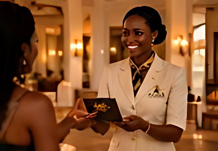 A member of staff handing a hotel booklet over to a guest