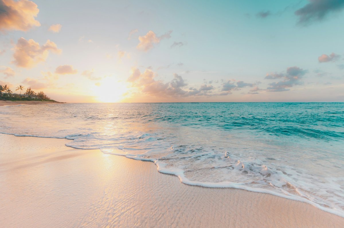 Sunrise over a white sand beach and calm turquoise water